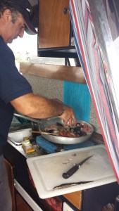 Captain Tore cooking up the best seasfood risotto on his boat in Sardinia